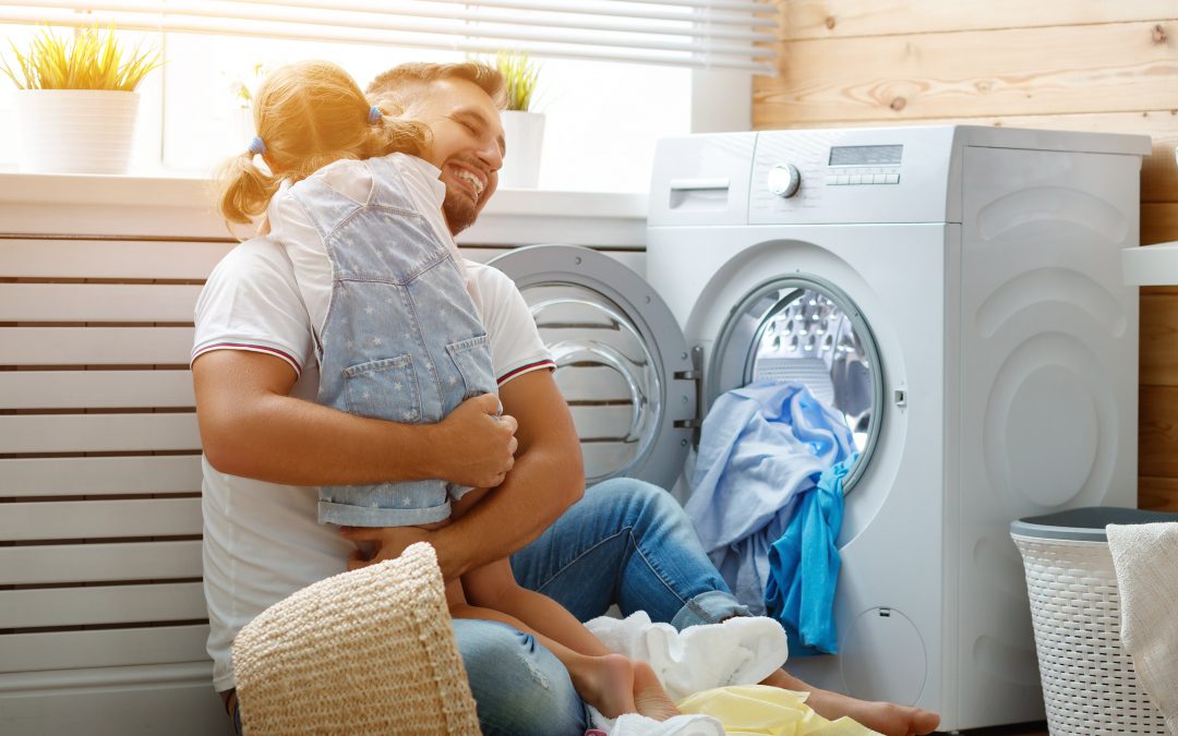 Famille heureuse : homme, père, propriétaire et enfant, fille, dans une buanderie avec une machine à laver. adoucisseur d'eau linge propre et plus doux