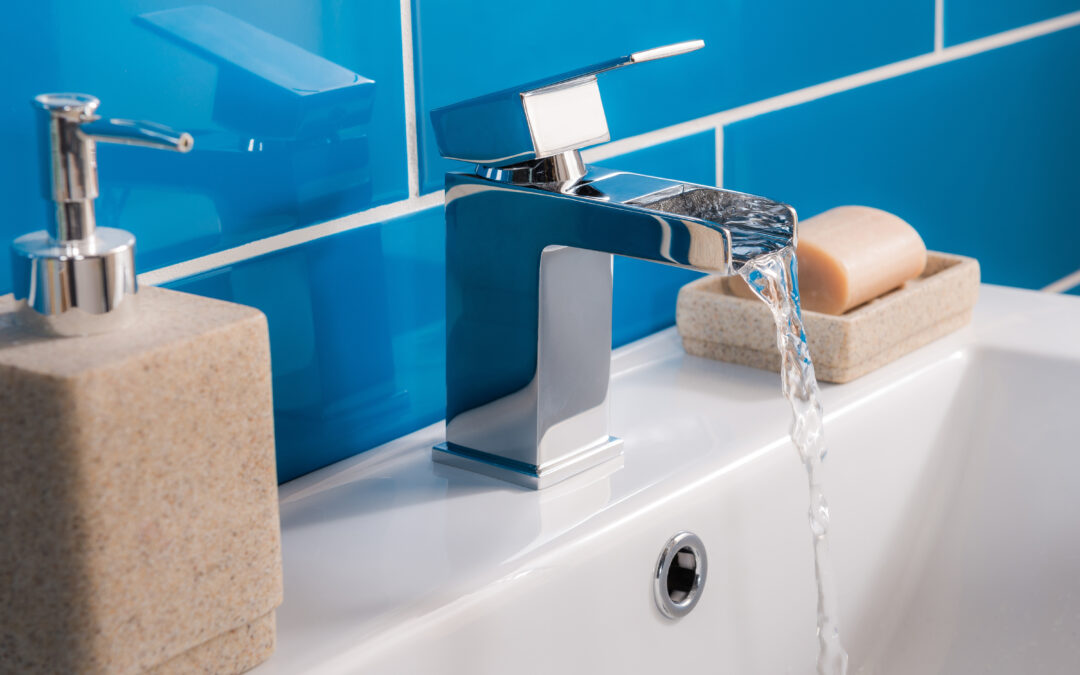 Nouveau robinet moderne en acier avec le lavabo en céramique dans la salle de bains calcaire eau dure